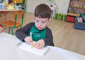 Dzieci kroją przygotowane owoce