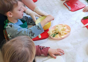 Dzieci kroją przygotowane owoce