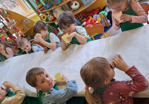 Dzieci piją przygotowany przez siebie koktajl owocowy