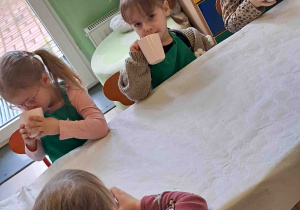 Dzieci piją przygotowany przez siebie koktajl owocowy