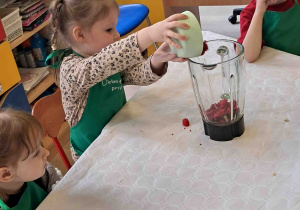 Dzieci wsypują owoce do blendera
