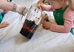 Dzieci wsypują owoce do blendera