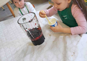 Dzieci wsypują owoce do blendera
