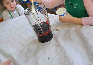 Dzieci wsypują owoce do blendera