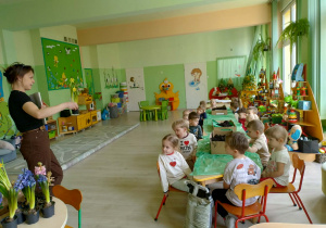 Pani florystka prowadzi zapoznaje dzieci z kwiatkami wiosennymi