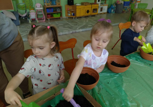 Dzieci wsypują ziemie do doniczek