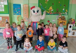 Grupa dzieci stoi z zajączkiem wielkanocnym