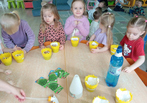 Grupa dziewczynek przygotowuje się do siewu ziarenek