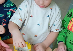 Chłopiec w białej koszulce sieje ziarenka