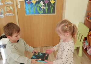 Chłopiec wręcza upominek koleżance.