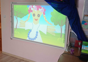 Dzieci oglądają wyświetlany filmik edukacyjny o Marzannie.