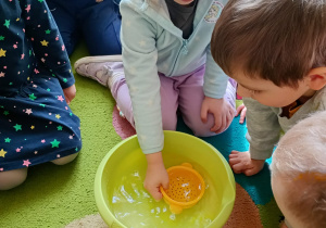 Dzieci eksperymentują z wodą.