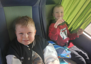 Dzieci wesoło pozują do zdjęcia w autokarze.