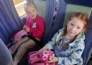 Dzieci wesoło pozują do zdjęcia w autokarze.