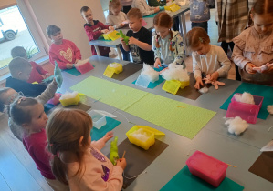 Dzieci uczestniczą w warsztatach z szycia maskotek.