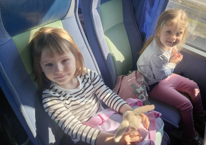 Dzieci wesoło pozują do zdjęcia w autokarze.