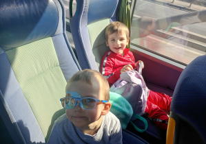 Dzieci wesoło pozują do zdjęcia w autokarze.