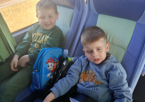 Dzieci wesoło pozują do zdjęcia w autokarze.