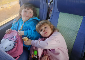 Dzieci wesoło pozują do zdjęcia w autokarze.