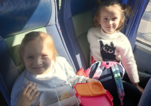 Dzieci wesoło pozują do zdjęcia w autokarze.