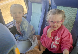 Dzieci wesoło pozują do zdjęcia w autokarze.