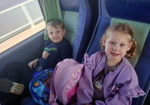 Dzieci wesoło pozują do zdjęcia w autokarze.