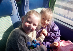 Dzieci wesoło pozują do zdjęcia w autokarze.