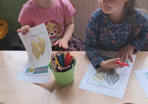 Dzieci przy stoliku wykonują karty pracy w tematyce Dnia Gofra
