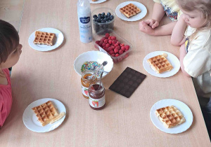 Dzieci przy stoliku przyrządzały gofry według własnego uznania