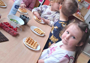 Dzieci przy stoliku przyrządzały gofry według własnego uznania