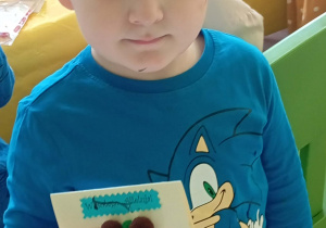 Chłopiec prezentuje swoją kartkę wielkanocną