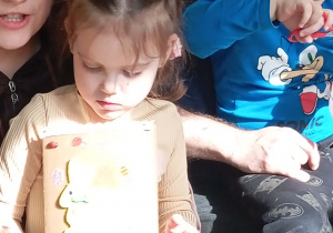 Dziewczynka prezentuje swoją kartkę wielkanocną