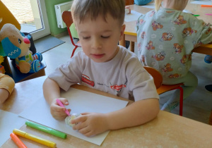 Chłopiec koloruje pisanke