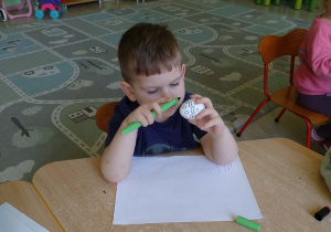 Chłopiec maluje pisanke