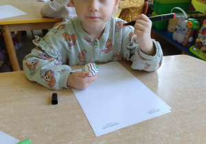 Dziewczynka koloruje pisanke