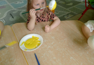 Dziewczynka koloruje styropianowe jajko