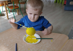 Chłopiec koloruje styropianowe jajko