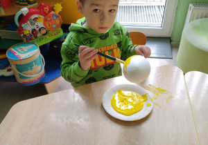 Chłopiec koloruje styropianowe jajko