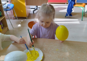 Dziewczynka koloruje styropianowe jajko