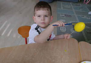 Chłopiec koloruje styropianowe jajko