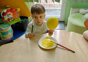 Chłopiec koloruje styropianowe jajko