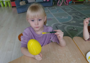 Dziewczynka koloruje styropianowe jajko