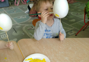 Chłopiec koloruje styropianowe jajko