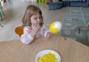 Dziewczynka koloruje styropianowe jajko