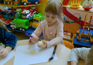 Dziewczynka koloruje pisanke