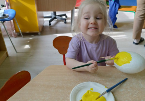 Dziewczynka koloruje styropianowe jajko