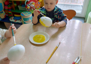 Chłopiec koloruje styropianowe jajko