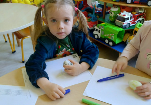 Dziewczynka koloruje pisanke