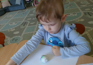 Dziewczynka maluje pisanke mazakami