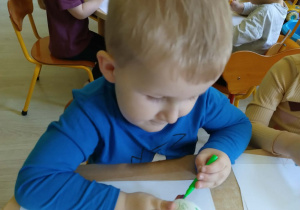 Chłopiec maluje pisanke